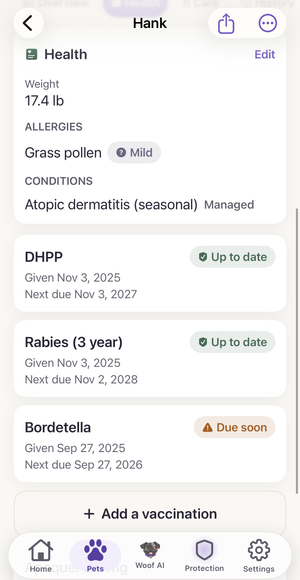Hank’s real Woof Pet Record health tab: his weight, a mild grass-pollen allergy, a managed condition, and his vaccinations, with DHPP and rabies up to date and Bordetella marked due soon.